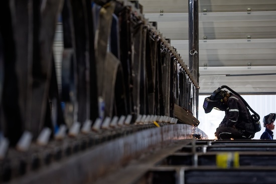 Un soudeur disparaît presque dans une immense structure métallique à l’usine BC Metalnord.